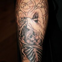 Hiding black death & skull forearm tattoo