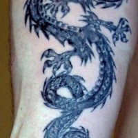 Le tatouage avant-bras d'un dragon noir cornu en colère