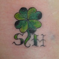 Le tatouage d'initiales avec un trèfle à quatre feuilles