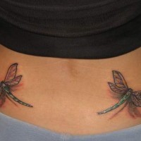 Tatuaje de dos pequeñas libélulas 3d en bajo espalda