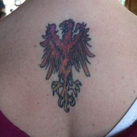 el tatuaje pequeño de la ave fenix de color rojo hecho en la espalda
