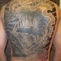 Un gros tatouage sur le dos avec un tigre asiatique marchant à pas de loup