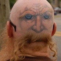 Funny face tattoo on bald head
