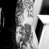 Dice cards and cherubs tattoo on arm