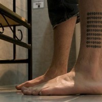 Binary code tattoo on leg