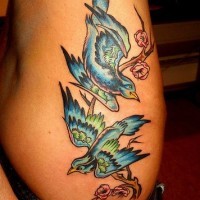 tatuaje elegante de pájaros azules en una rama