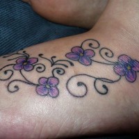 tatuaje femenino en el pie de tracería de flores