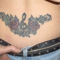 Musikalische rote Rosen Tattoo am unteren Rücken