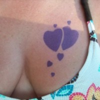 Lila Herzen Tattoo an der Brust