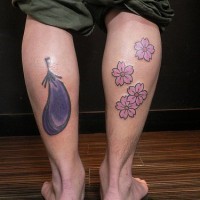 Le tatouage de l'aubergine et des fleurs sur les jambes