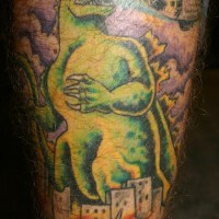 Mostruoso tatuaggio colorato sulla gamba Godzilla in città