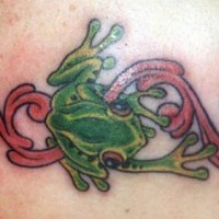 Green frog on pink tracery tattoo
