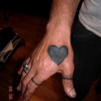 Tatuaje en la mano, corazón grande negro