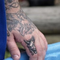 Grande angelo non colorato tatuato sulla mano e piccolo diavolo tatuato sul dito