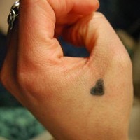 Einfaches Tattoo von kleinem Herzen in Schwarz an der Hand