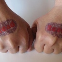 Les empreintes de doigts avec le tatouage d'une inscription rouge sur la main