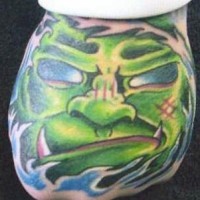 Tattoo von grünem hässlichem Monster mit Eckzähnen an der Hand