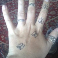 Tatuaje en la mano, cuatro mariposas similares descoloridos