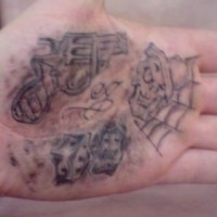 Tattoo von Pistole, Spielkarten und Totenkopf auf der Handfläche