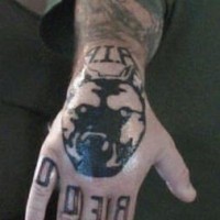Tattoo von gefährlichem Hundekopf und Namen in Schwarz an der Hand
