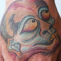 Tattoo von hässlichem Lebewesen mit großen Augen an der Hand