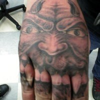 Tattoo von fürchterlichem hornigem Teufel mit scharfen Zähnen an der Hand