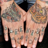 La farfalla, la tigre tatuati sulle mani e piccolo disegno con la lettera su ogni dito tatuati