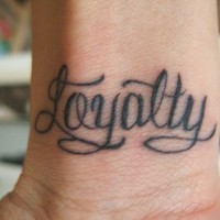 Calligraphic tattoo with word Loyalty on inner side of hand
