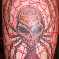 Tatouage de crâne avec un signe de harley davidson sur le mollet et de toile d'araignée