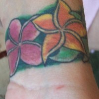 Le tatouage sur le poignet avec une fleur hawaïenne