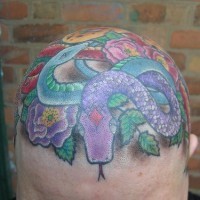 Tatuaggio variopinto sulla testa il serpente pronto per attaccare e fiori grandi