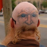 Head tattoo, man's  face with blue eyes
