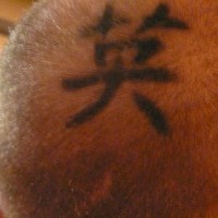 Head tattoo with big, black hieroglyph