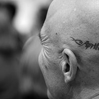 Black, neat, designed inscription head tattoo