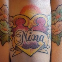 tatuaje de corazón dorado con flores