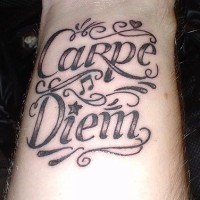 Carpe diem calligraphic wrist tattoo