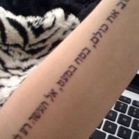 Hebrew lettering arm tattoo
