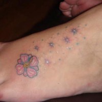 Hibiscus mit leuchtendem Stern Tattoo am Fuß