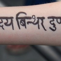 Le tatouage des écrits en sanskrit sur le bras