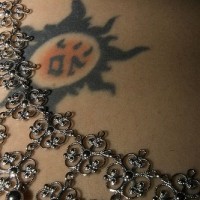 Tatuaje en la cadera, sol con rayos negros