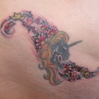 Tatuaje en la cadera, unicornio con el cabello dorado y flores multicoles