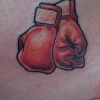 Tatuaje en la cadera, guantes de boxeo rojos