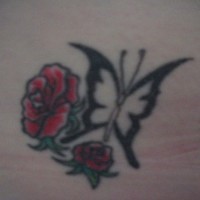 Tattoo von zwei klenen roten Rosen und schwarzem Schmetterling an der Hüfte