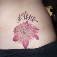 Tattoo von rosa Lilie und stilisiertem Namen an der Hüfte