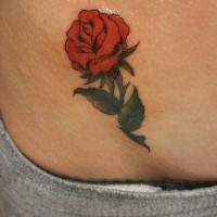 Une belle rose pittoresque le tatouage sur la hanche