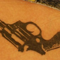 Big, black, realistic gun hip tattoo