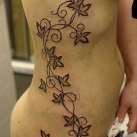 Tatuaje en la cadera, planta con flores a lo largo del cuerpo