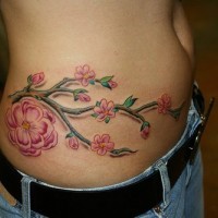 Tattoo von sehr schönen kleinen und großen Blumen an der Hüfte