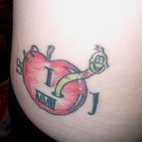 Worm smiling from red apple hip tattoo