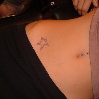 Tattoo von winzigem nichtfarbigem Stern an der Hüfte